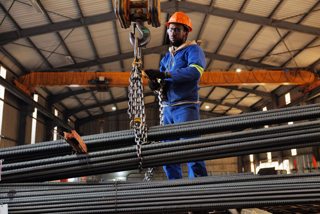 RMS Durban team member using an overhead crane to move bundles of reinforcing steel in the Pinetown warehouse