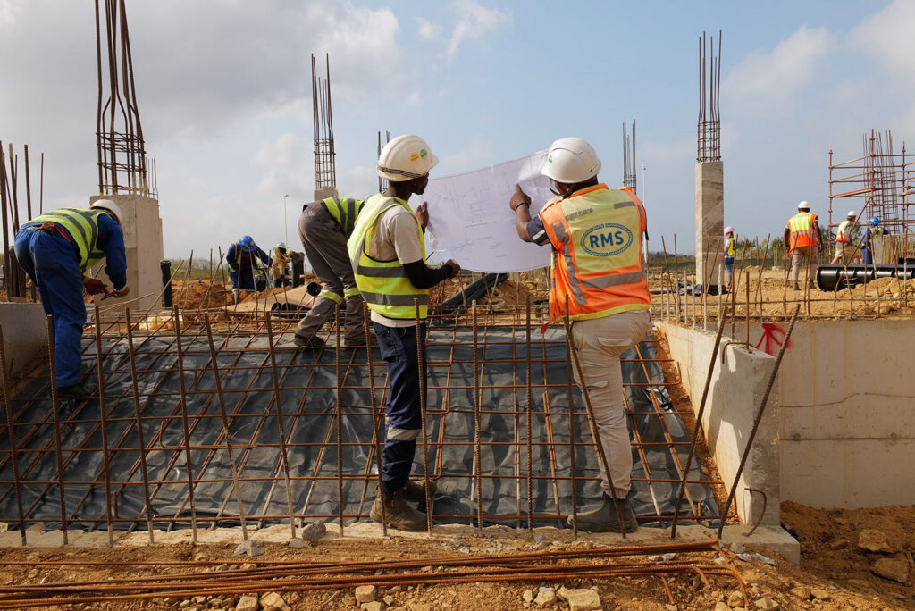 Welded Mesh and Cut and Bend for Coastal Builds in Durban and Richards Bay 13 Site team reviewing a reinforcement layout plan on a reinforced slab in KwaZulu-Natal