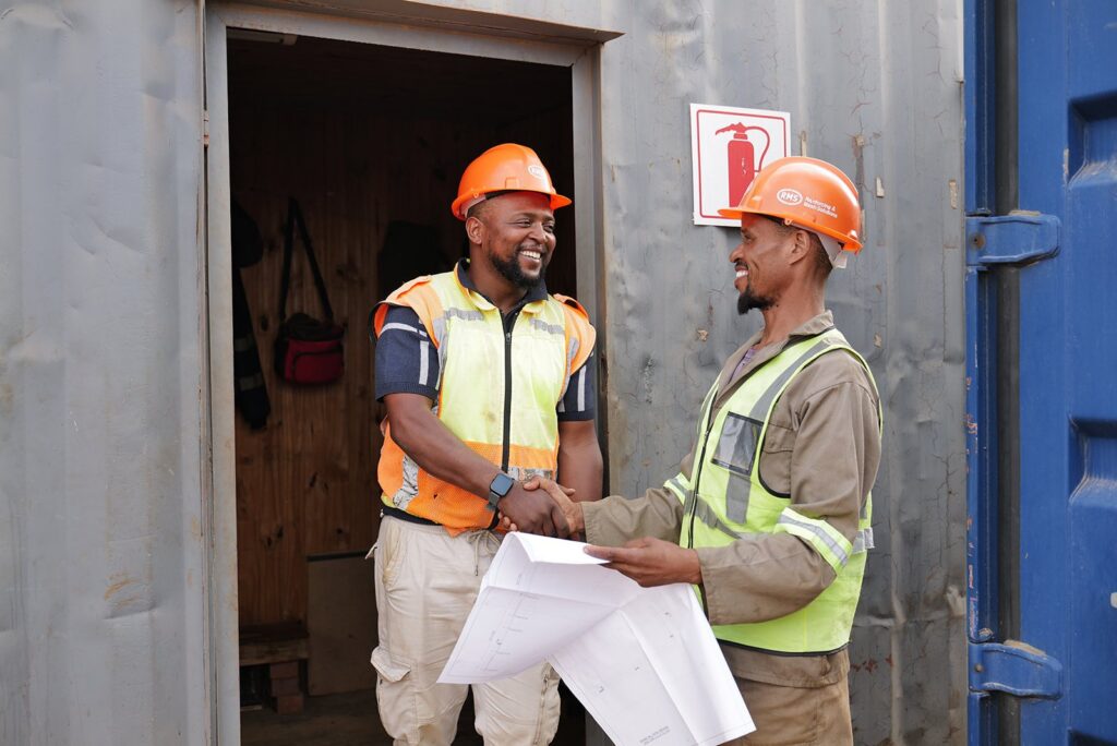 Welded Mesh and Cut and Bend for Coastal Builds in Durban and Richards Bay 17 Site team shaking hands over construction drawings in KwaZulu-Natal