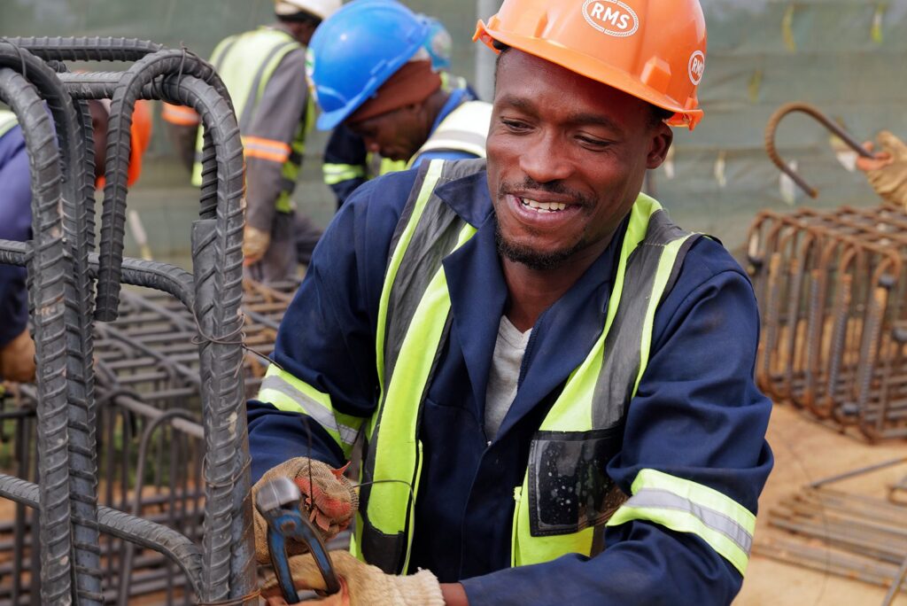 Welded Mesh and Cut and Bend for Coastal Builds in Durban and Richards Bay 15 Smiling steel fixer at a reinforcement cage on a KwaZulu-Natal construction site