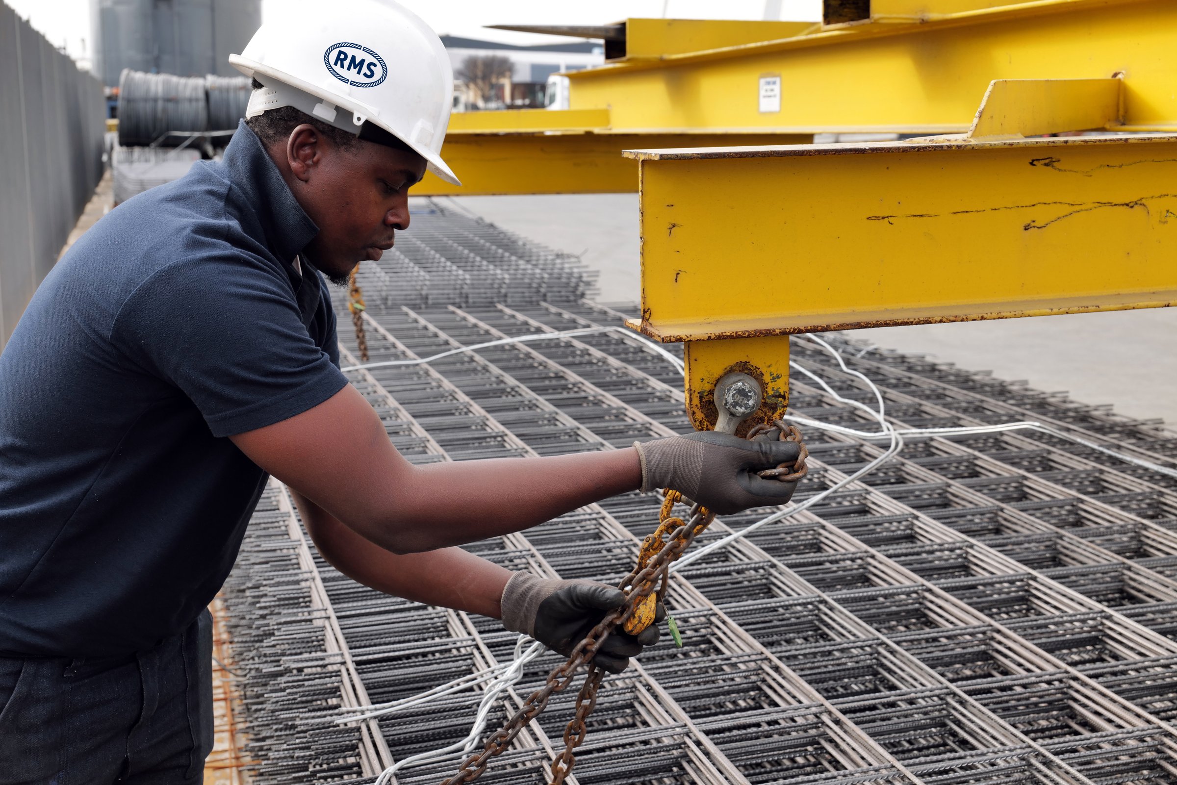 Welded Mesh and Cut and Bend in Johannesburg: Fast, Reliable Supply for Gauteng Sites 1 RMS team member hooking a lifting chain over welded mesh sheets at the Johannesburg branch in Germiston